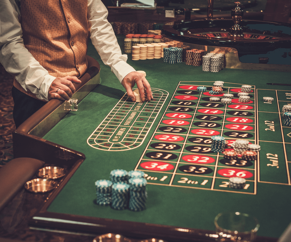 Casino roulette table with chips and dealer.