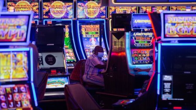 Person playing slot machines in a casino.
