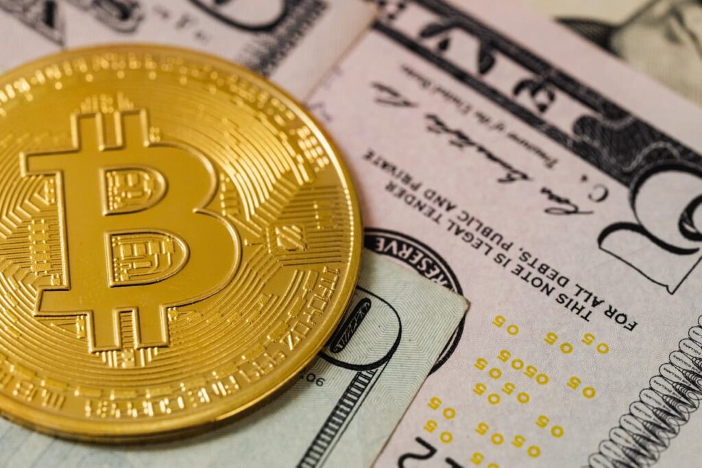 Bitcoin coin on US dollar bills.